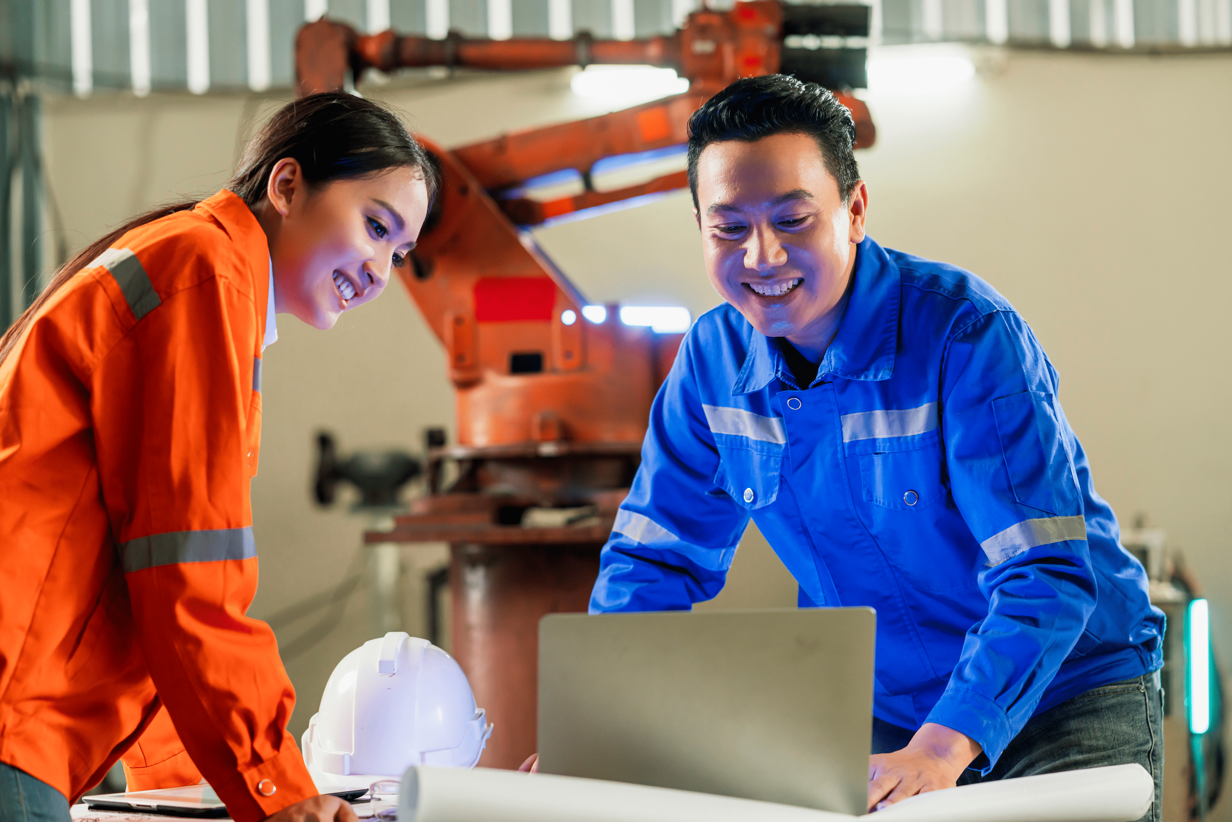 engineer-cooperation-two-asian-male-female-technician-maintenance-inspect-relay-robot-system-with-tablet-laptop-control-quality-operate-process-work-heavy-industry-40-manufacturing-factory 1